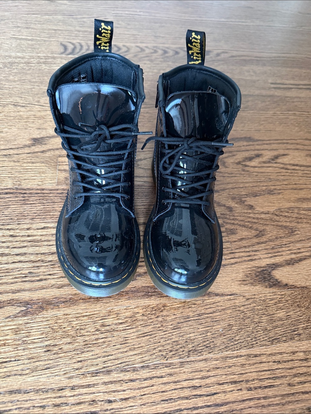 Dr. Martens Black Patent Lace-Up Boots with Yellow Pull Tabs.